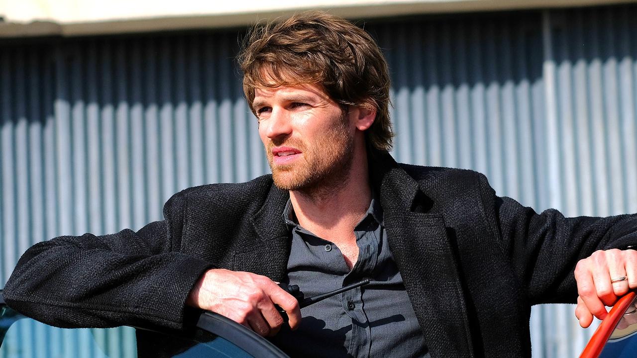 Maigret star Benjamin Wainwright leaning on a car.