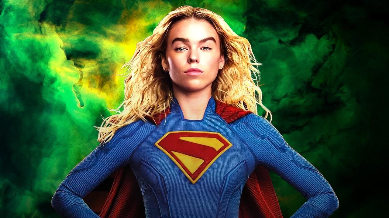 Milly Alcock's Supergirl posing in front of a green wallpaper.
