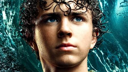 Walker Scobell as Percy Jackson with a wave behind him in Percy Jackson and The Olympians