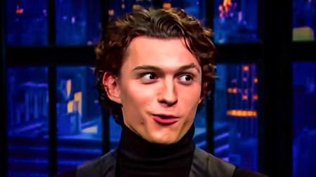 Tom Holland with long hair getting interviewed on Seth Meyers