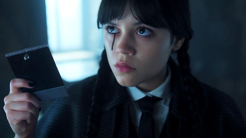 Jenna Ortega holding a photograph in in Wednesday Season 2