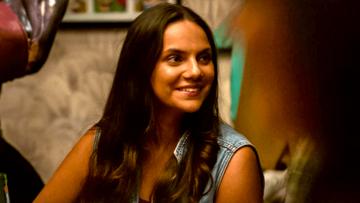 Daphne Keen as X-23 sitting at a table, smiling, in Deadpool & Wolverine.