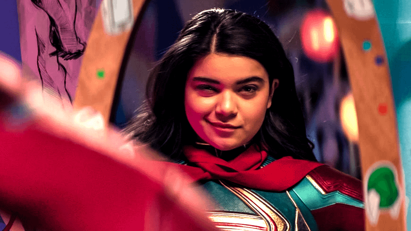 Iman Vélani Kamala Khan Ms Marvel in superhero suit looking in mirror.