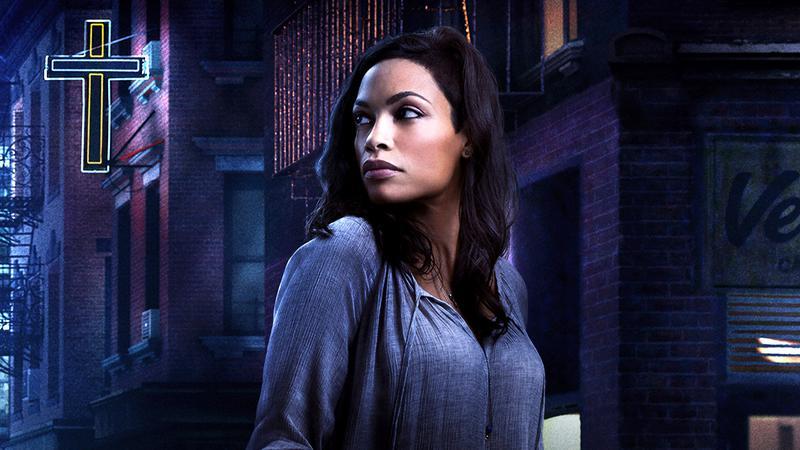 Rosario Dawson as Claire Temple standing in a street in Daredevil.