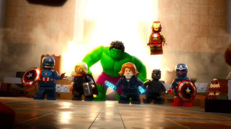 The Avengers together with a big hole in a wall behind them in LEGO Marvel Avengers: Strange Tails