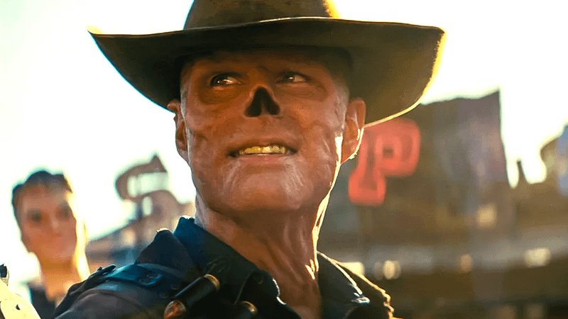 Walton Goggins looks up and smiles as The Ghoul in front of a post-apocalyptic backdrop in Prime Video's Fallout series