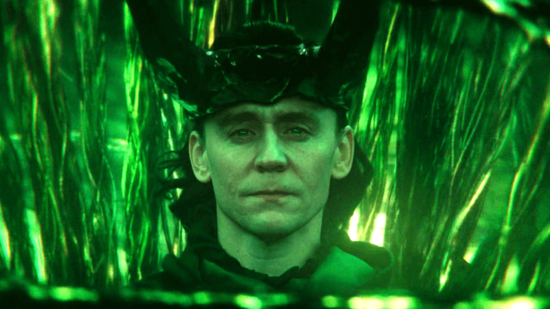 Loki sits among green strands of timelines as the God of Stories in Loki Season 2.