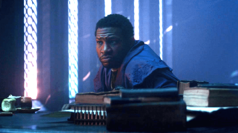 Jonathan Majors' He Who Remains stares across his desk at Loki and Sylvie in Loki Season 1.