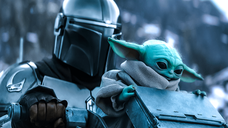 The Mandalorian and Grogu riding a speeder.