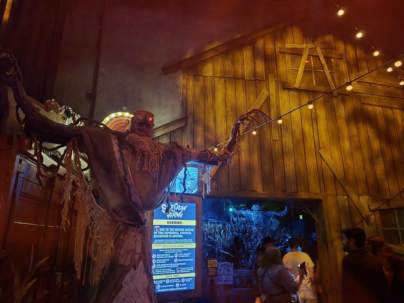 Statue of a creepy scarecrow in front of 'Scarecrow: The Reaping' haunted house.
