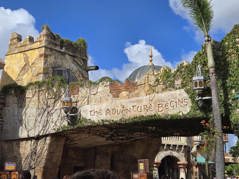Entrance to Islands of Adventure with text 'The Adventure Begin's written on stone.