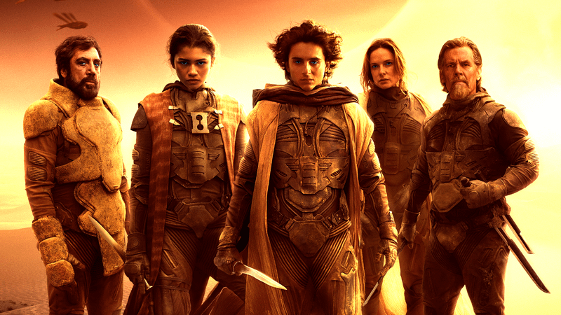 The cast of Dune standing together with the sun setting in the background in Dune