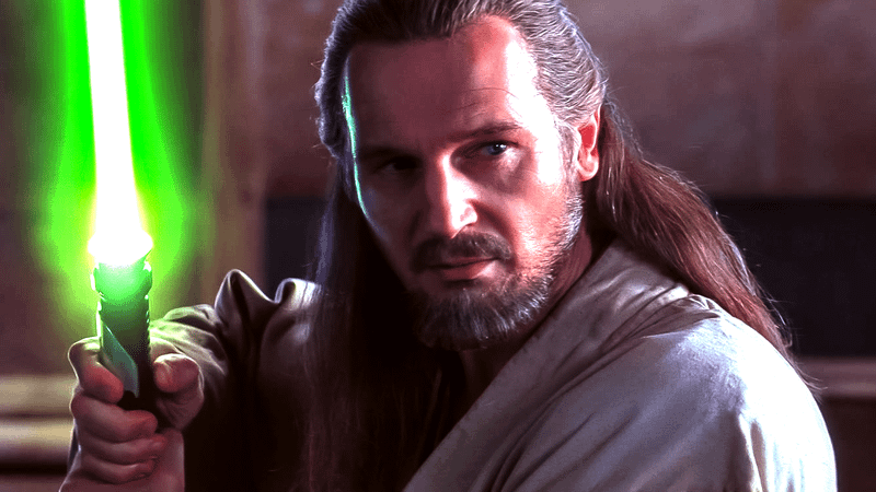 Jedi Master Qui-Gon Jinn grips a green saber.