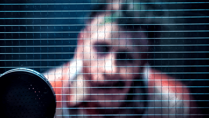Barry Keoghan as Joker looking through some glass in The Batman.
