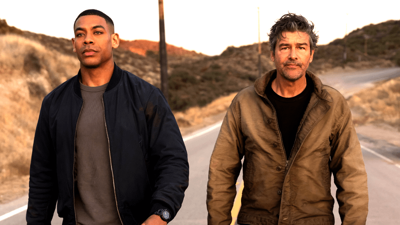 Aaron Pierre as John Stewart and Kyle Chandler as Hal Jordan walking down a street in Lanterns
