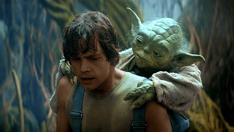 Luke Skywalker with Yoda on his back in Star Wars: Empire Strikes Back