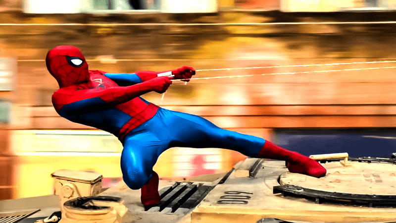 Spider-Man setting up to launch himself off a tank with his webs.