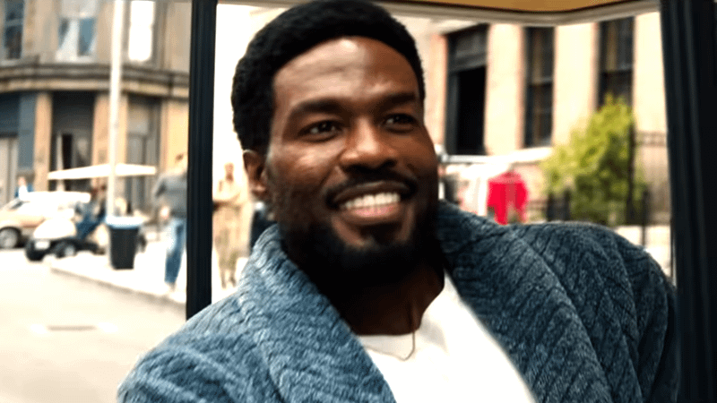 Yahya Abdul-Mateen II as Wonder Man driving in a golf cart in a house coat in Wonder Man