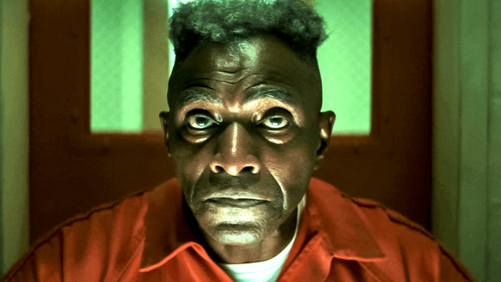 Isaiah Bradley sitting in a prison wearing a jumpsuit.
