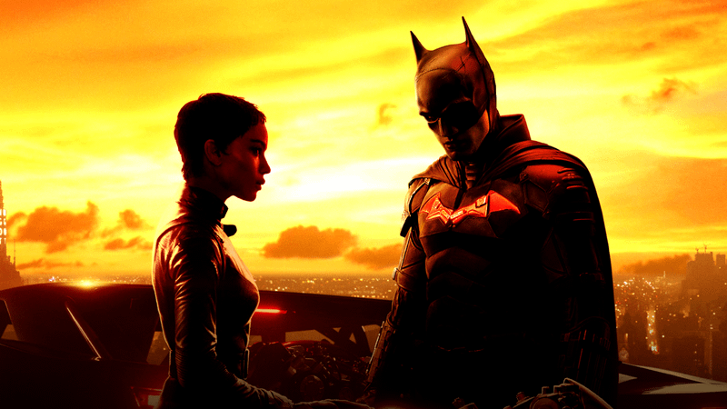 Catwoman and Batman standing next to the Batmobile