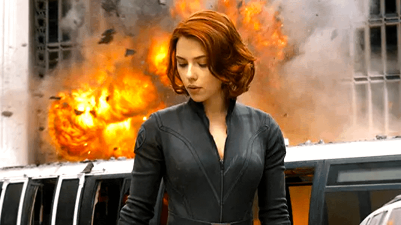 Scarlett Johansson as Black Widow looking to her side with an explosion in the background in The Avengers