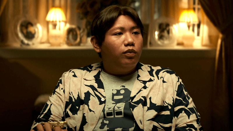Jacob Batalon as Ned Leeds sitting in a dining room in Spider-Man: No Way Home