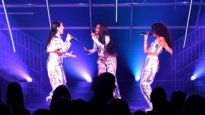 3Quency singing on stage in Building the Band