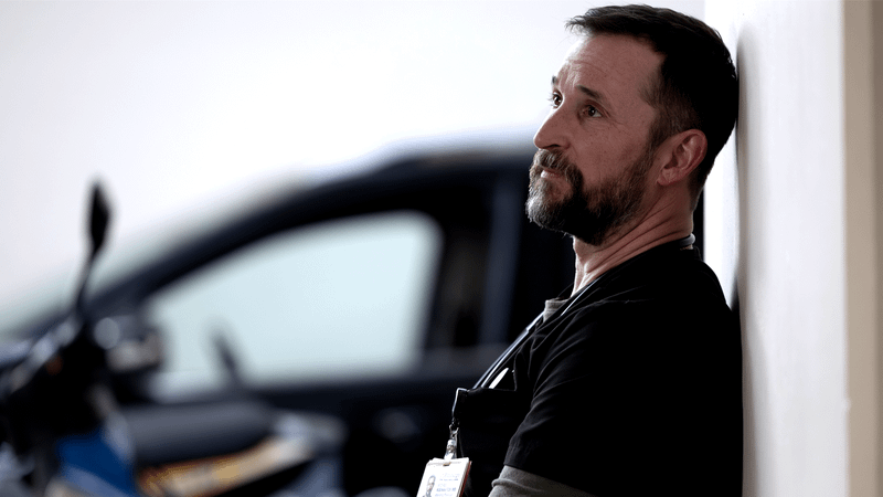 Noah Wyle as Dr. Robby looking at something in The Pitt Season 2, Episode 14.