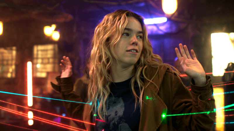 Kara with her hands up and lasers pointed at her.