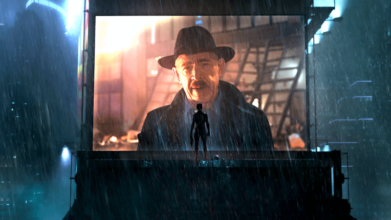 Tom Holland as Peter Parker standing in the rain looking up at a large LED screen with an image of J.K. Simmons' J. Jonah Jameson on it in Spider-Man: No Way Home