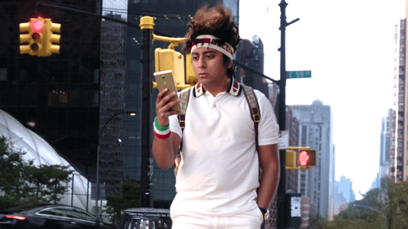 Tony Revolori as Flash Thompson walking down a street in Spider-Man: No Way Home