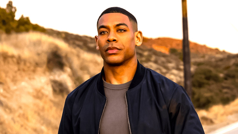 Aaron Pierre as John Stewart walking down a dusty road in Lanterns