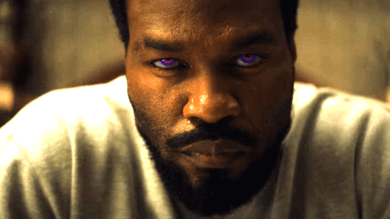 Yahya Abdul-Mateen II stares into the camera as Simon Williams as his eyes glow red in Wonder Man