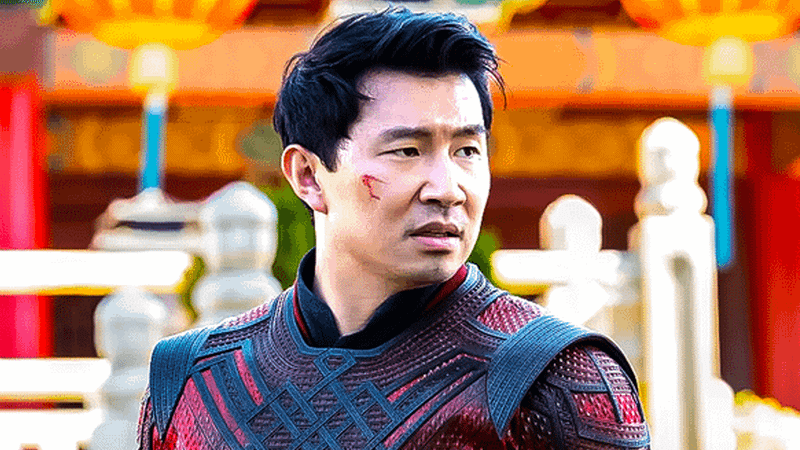 Simu Liu as Shang-Chi standing in his read dragon-scale outfit in Shang-Chi andthe Legend of the Legend of the Ten Rings