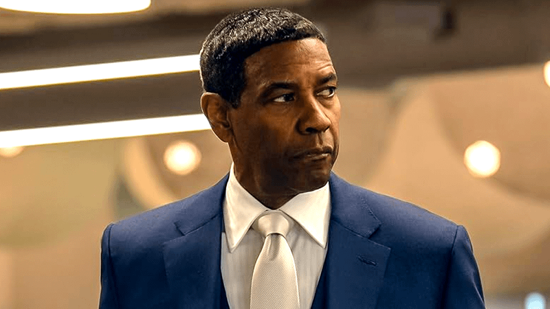 Denzel Washington in a blue suit, white shirt, and white tie.