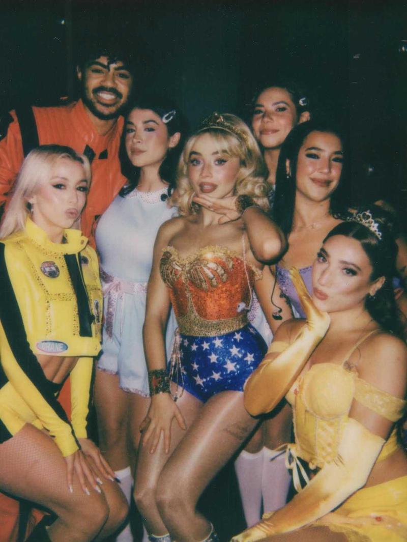 Sabrina Carpenter dressed as Wonder Woman next to backup dancers in costumes
