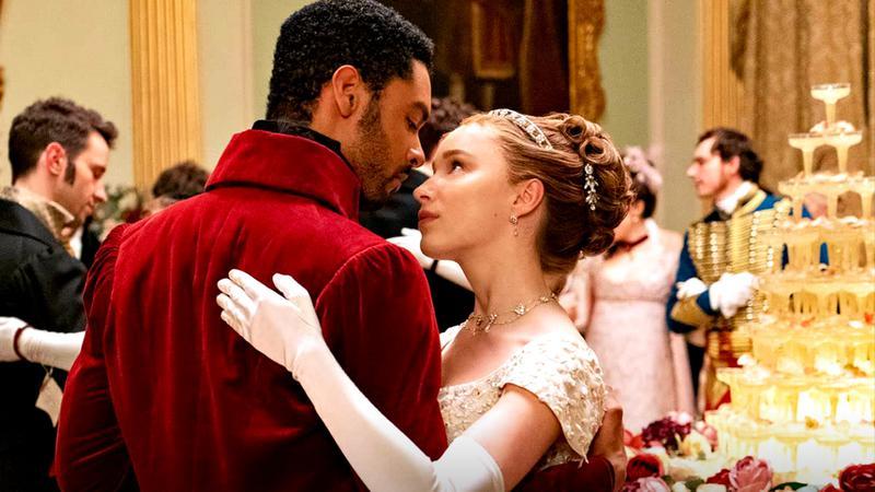 Phoebe Dynevor as Daphne Bridgerton holding Rege-Jean Page at a dance in Bridgerton Season 1