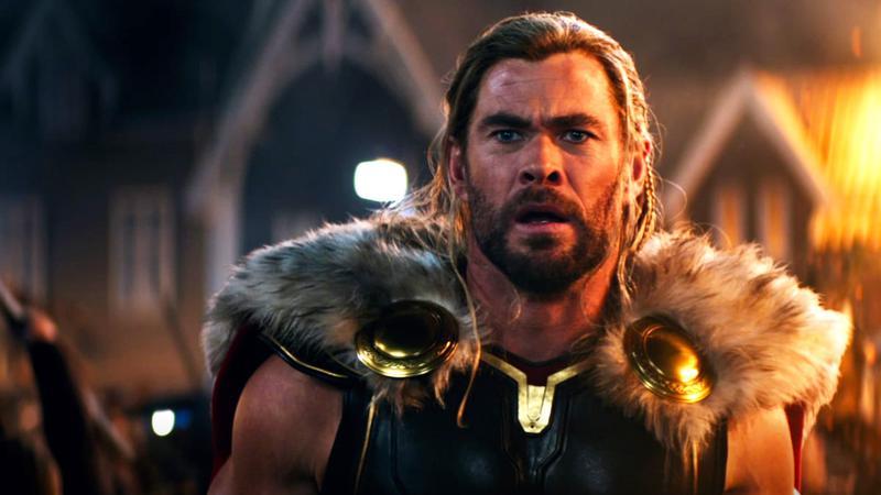 Chris Hemsworth as Thor in a fiery village in Thor: Love and Thunder