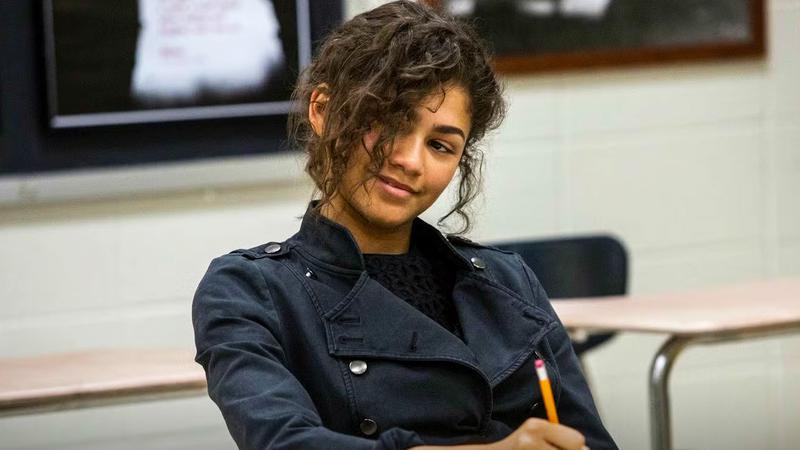 Zendaya as MJ sitting at a desk with a pencil in her hand in Spider-Man: Homecoming