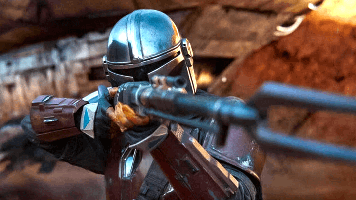 The Mandalorian holding his Amban Phase-Pulse Blaster.