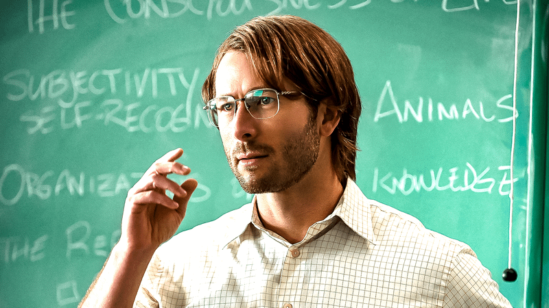 Glen Powell as Gary Johnson wearing a wig and glasses in Hit Man