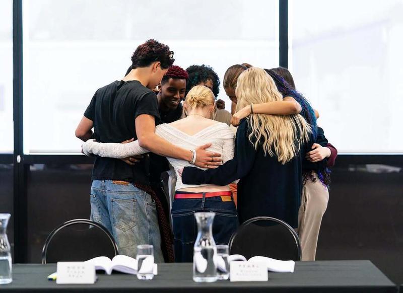 Zombies 5 cast hugging each other.