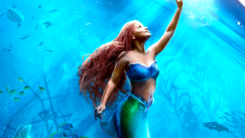 Halle Bailey as Ariel reaching for the surface of the water in The Little Mermaid