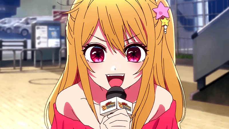 A pop singer talking into a microphone in Ochi No Ko