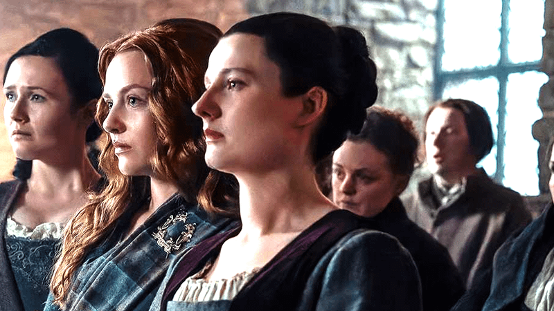 Ailsa Davidson as Janet MacKenzie standing with a group of people in Outlander: Blood of my Blood