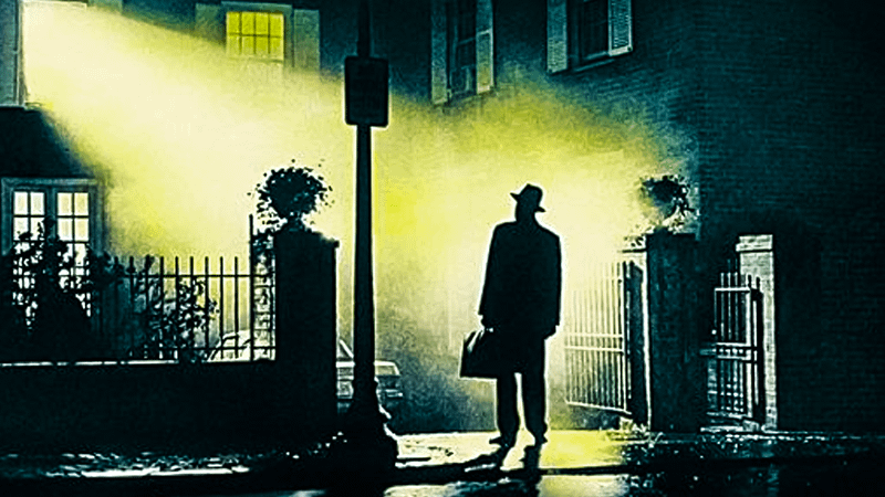 A shadowy man standing outside a home in The Exorcist