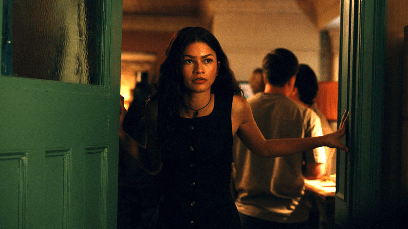 MJ standing in a doorway in her apartment.