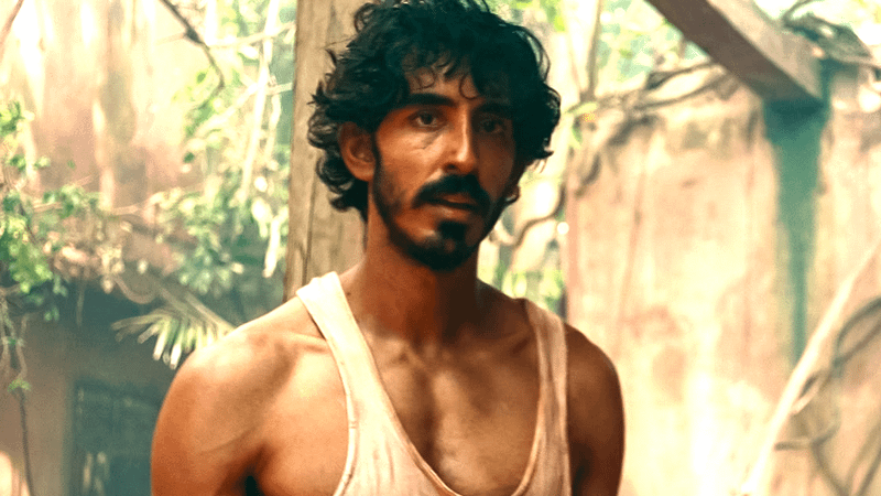 Dev Patel as Kid standing in a tank top in Monkey Man