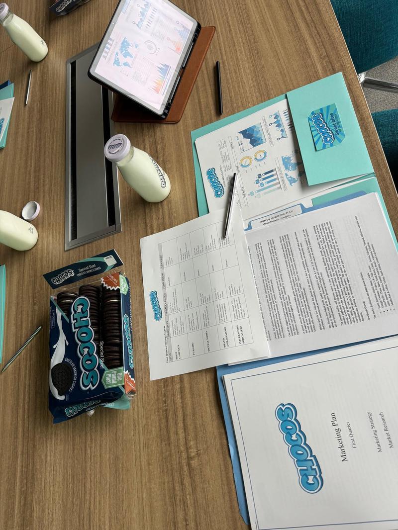 Chocos office desk with a presentation deck laid out in a folder.