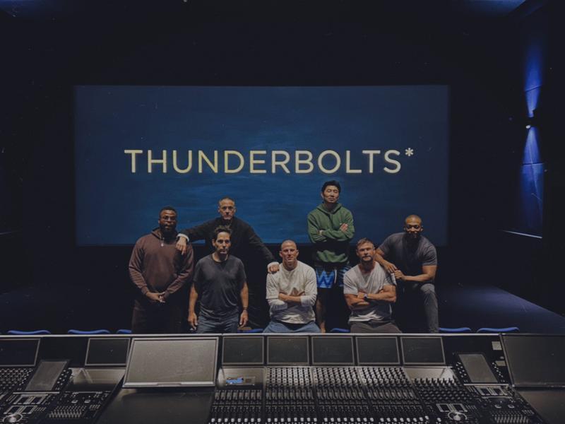Winston Duke, Paul Rudd, Robert Downey Jr., Channing Tatum, Simu Liu, Chris Hemsworth, and Anthony Mackie sitting in front of a screen with Thunderbolts* title card